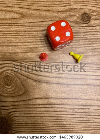 Red dice and game pieces on wood background