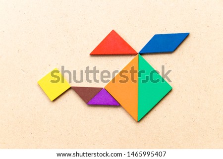 Color tangram puzzle in copter or helicopter shape on wood background