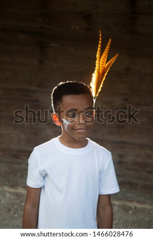 Lost Boy Black male child with modern tribal paint and feathers