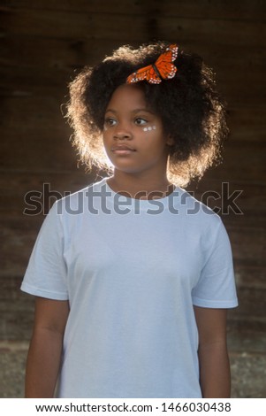 Lost Girl Black Girl with afro and butterfly in her hair with a white shirt