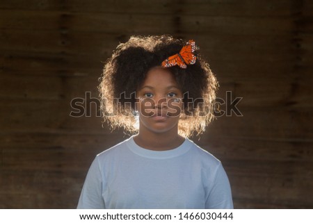 Lost Girl Black Girl with afro and butterfly in her hair with a white shirt