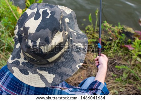 Top view of a fisherman, a fisherman man near the water with a fishing rod on a quiet calm evening