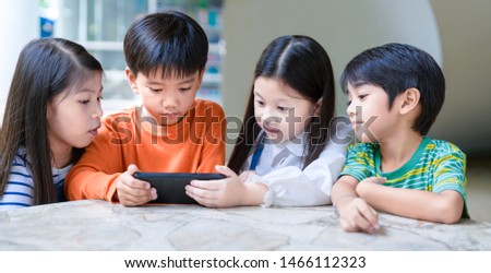 Smartphone Addiction group of little children watching film movie cartoon together on digital tablet. Kids playing with tablet with friends