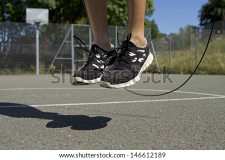 Close up of male feet jumping in mid air whilst using a Skipping Rope Royalty-Free Stock Photo #146612189