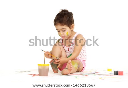 Portrait of lovely young girl draws painting while sitting on the floor