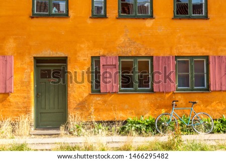 Picturesque of Copenhagen. Old yellow house of Nyboder district with bike. Old Medieval district in Copenhagen, Denmark