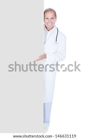 Portrait Of Mature Doctor Holding Placard Over White Background