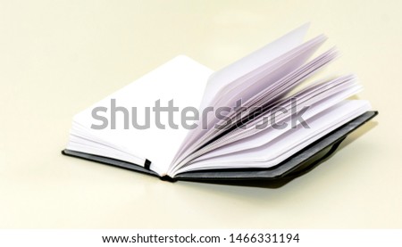 open hardcover notebook on a white table. Unwritten blank pages.