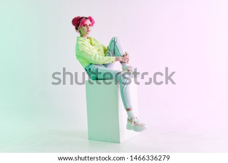 woman with pink hair sit on a cube
