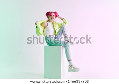woman with pink hair sits on a cube fashion style