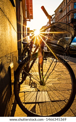 Rays of sun coming through the bicycle silhouette, bike at sunset.