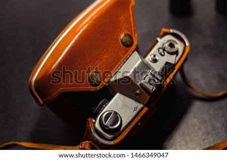 Half-opened leather case with an old camera. Shooting from top to bottom. Selective focus