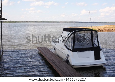 Boats parking - The modern powerboat on the mooring on cloudy the sky a background