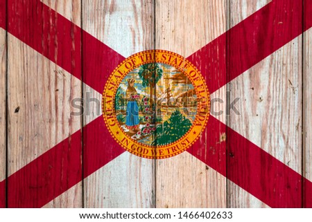 Florida US state national flag on a gray wooden boards background on the day of independence in different colors of blue red and yellow. Political and religious disputes, customs and delivery.