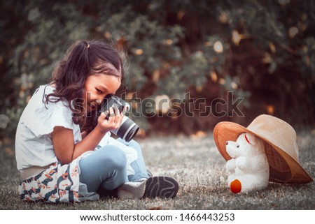 Shot of an unidentifiable young girl using a camera to take photos of his teddy in the woods 