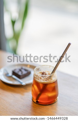 Sparkling Raspberry iced Americano coffee on wooden background with natural window light.