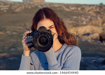 Cheerful woman with a camera on the nature landscape lifestyle