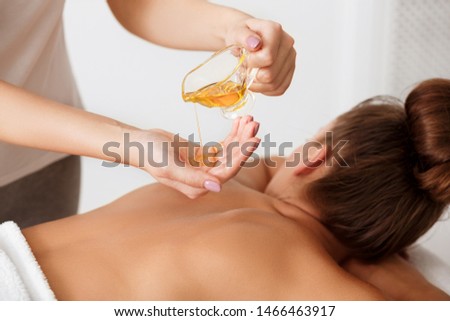 Spa massage. Masseur doing aromatherapy oil massage on woman body in spa salon Royalty-Free Stock Photo #1466463917