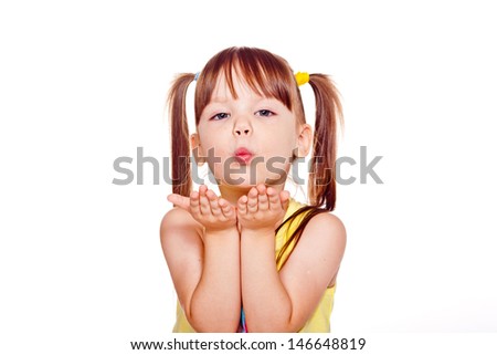 portrait of a little girl in the yellow shirt, a kiss, studio