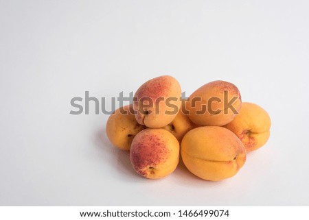 A handful of ripe apricots on a white background.