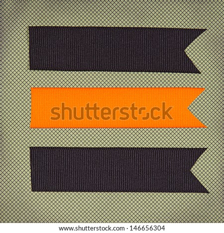 Halloween colored ribbon tags on a scrapbook paper background