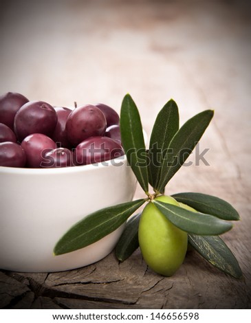 Olives with leaves on a wooden background.