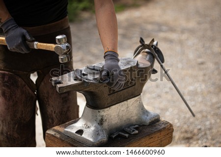 Farrier at work with iron horseshoe Royalty-Free Stock Photo #1466600960