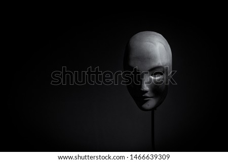 Female ceramic mask on black background from right profile
