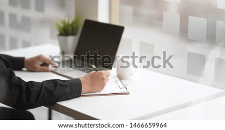 Motivated business man focusing on his project while using laptop 