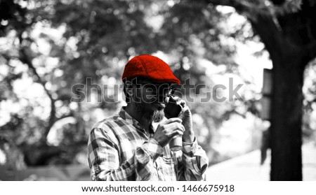 Man wearing a red hats taking tea standing in a place