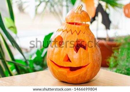 Bright scary pumpkin on a religious feast Halloween. Pumpkin on the table. Autumn tradition.