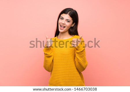 Teenager girl  over isolated pink wall with thumbs up gesture and smiling