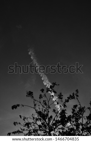 Minimal black and white photo with aircraft emission, creating moody vibe.