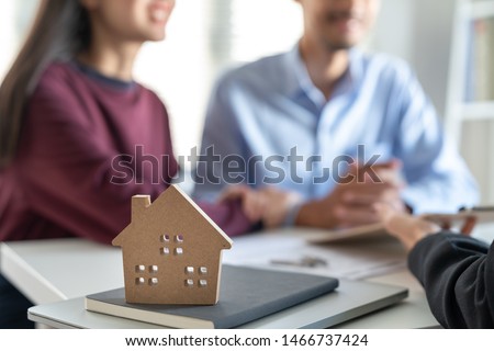Young family couple talking with property real estate agent about home loan contract purchase agreement