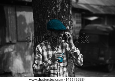 Man wearing a blue hats and taking tea standing in a place