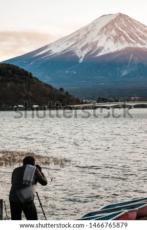 A Photographer in Black Jacket with Grey Scarf with Aerial Skyline of Fuji Mountain. Iconic and Symbolic Mountain of Japan. Scenic Landscape of Fujisan at Sunset time, Kawaguchiko, Yamanashi, Japan.