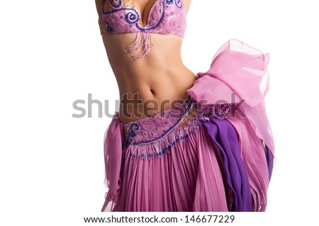 Torso of a female belly dancer wearing a pink costume and shaking her hips. Isolated on white. Royalty-Free Stock Photo #146677229