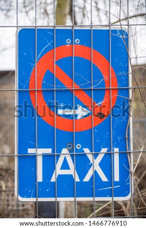 german taxi only traffic sign, behind a metal fence