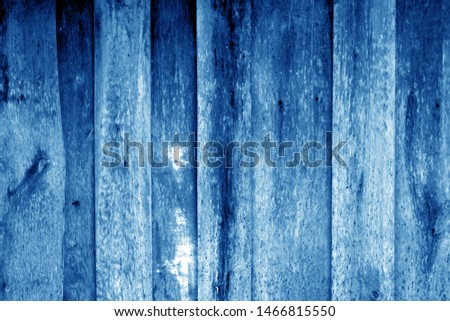Weathered wooden fence in navy blue color. Abstract background and texture for design.