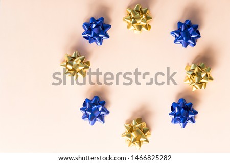 Gift wrapping. Modern Christmas gifts presents.Object for wrapping present boxes.Circle of gold and blue bows on pastel background. Holiday's ribbon bows for decoration gifts. Winter holidays