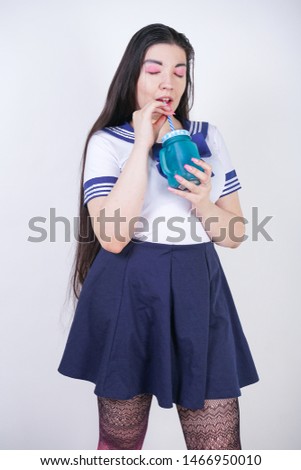cute asian cosplay woman with chubby body stands with cup