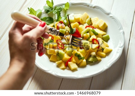 Juicy fresh organic colorful salad with melon on white wooden table
