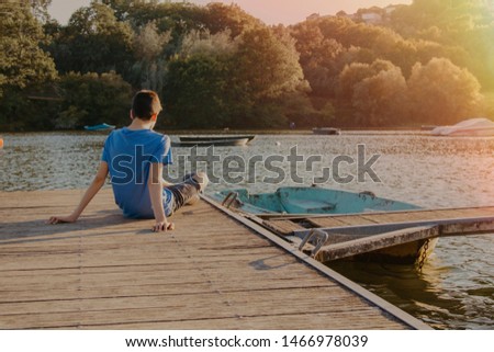 young or teen boy on the jetty at sunset