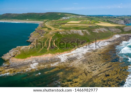 Aerial drone view of waves breaking onto sea cliffs on a summers day