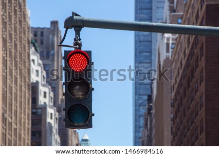 Traffic light closeup with red signal. Traffic light on the background of skyscrapers in New York. Red color traffic light with buildings in the background. Traffic light wallpaper.