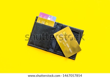 Pay by card concept and wallet on yellow background top view
