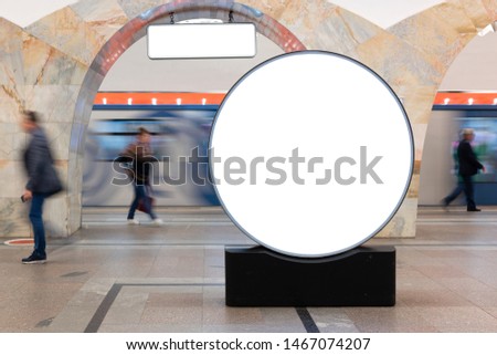 Moc up lightbox at metro station. Blurred movement people against background mock up large round lightbox and train movement. Advertising in subway, large lobby.
