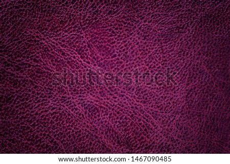 Lacquered dark purple leather texture background, closeup. Wine backdrop from wrinkle skin, structure of textile with vignette