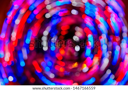Abstract texture with light round coloured red and blue bokeh and black background. Christmas designe