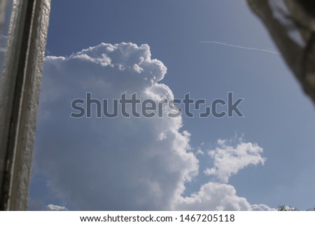 blue sky and a big white cloud outside the window